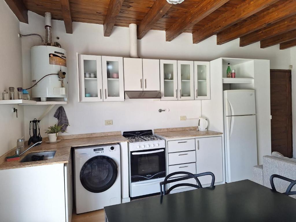 瓜伊马延Departamento de Noah的厨房配有白色橱柜、洗衣机和烘干机