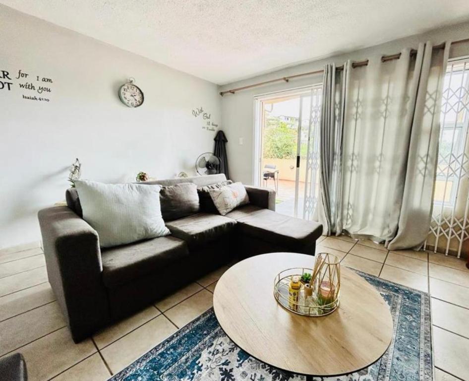 德班Makwande Self-Catering Apartment的客厅配有沙发和桌子