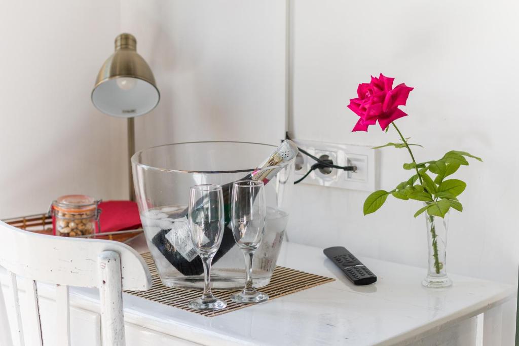 PieraLa Casa Vella EL BEDORC的一张桌子,上面放着两杯酒,还有一个玫瑰花瓶