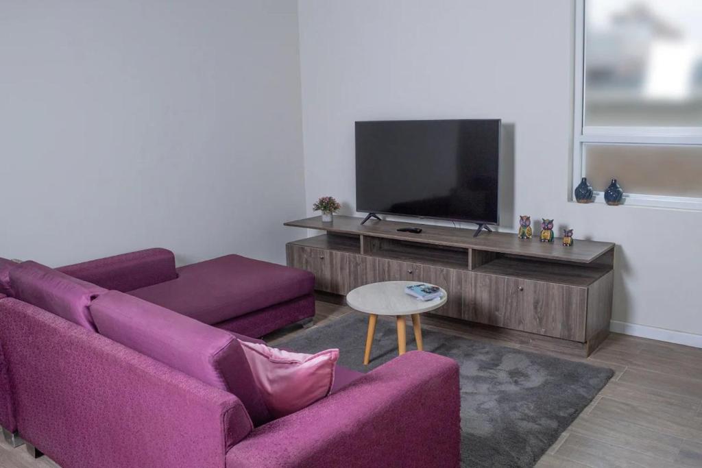 利马Departamento Amoblado的客厅配有紫色沙发和电视