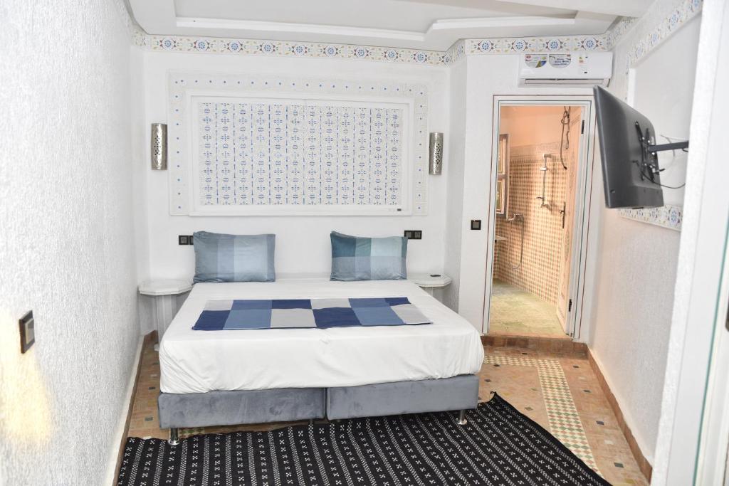 梅克内斯Golf Stinia hôtel & Spa的一间带床和电视的小卧室