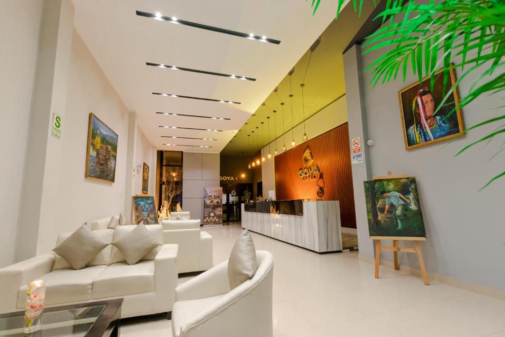 哈恩GOYA HOTEL的大堂设有白色的沙发和墙上的绘画作品