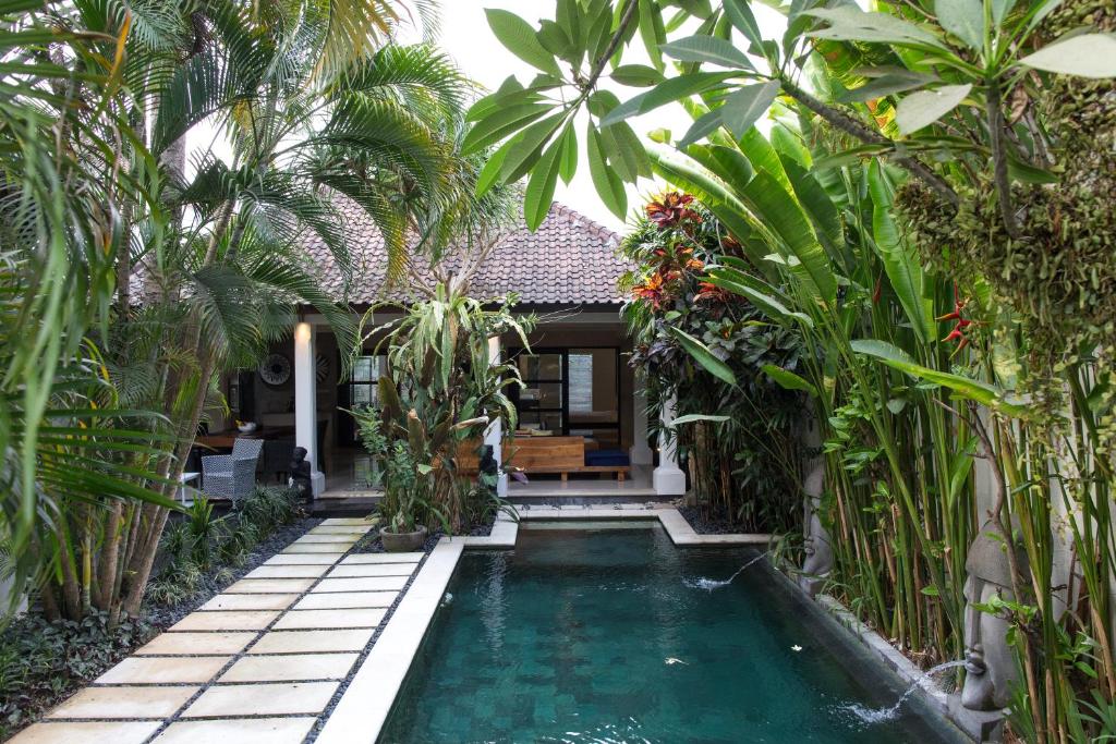 坎古Villa Cantik的棕榈树屋前的游泳池