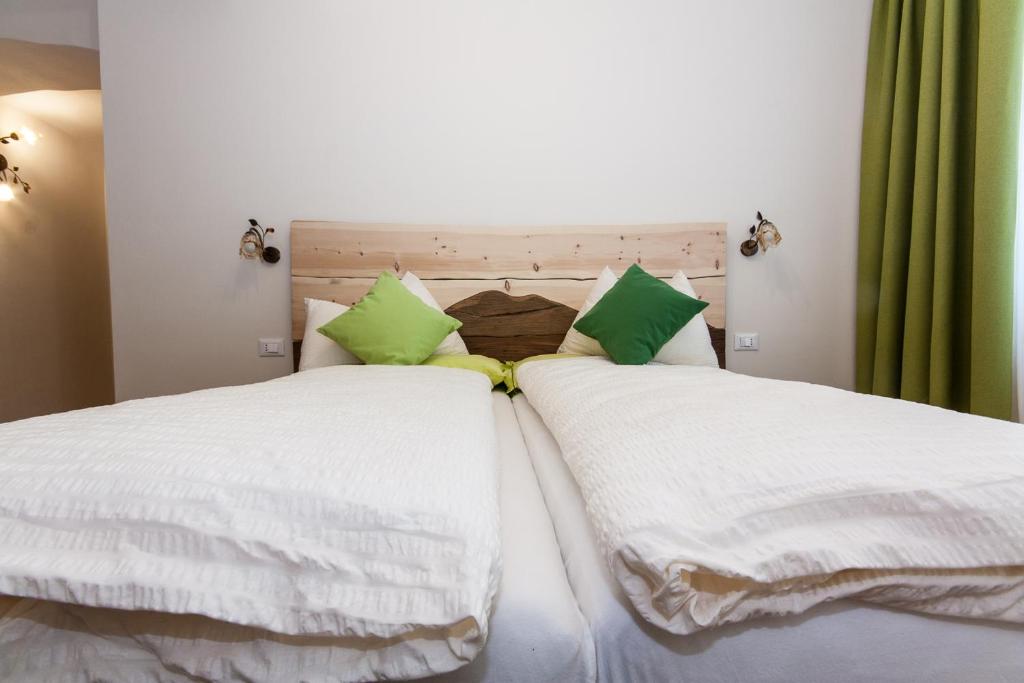 斯尔斯因坎托住宿加早餐旅馆的两张带白色床单和绿色枕头的床