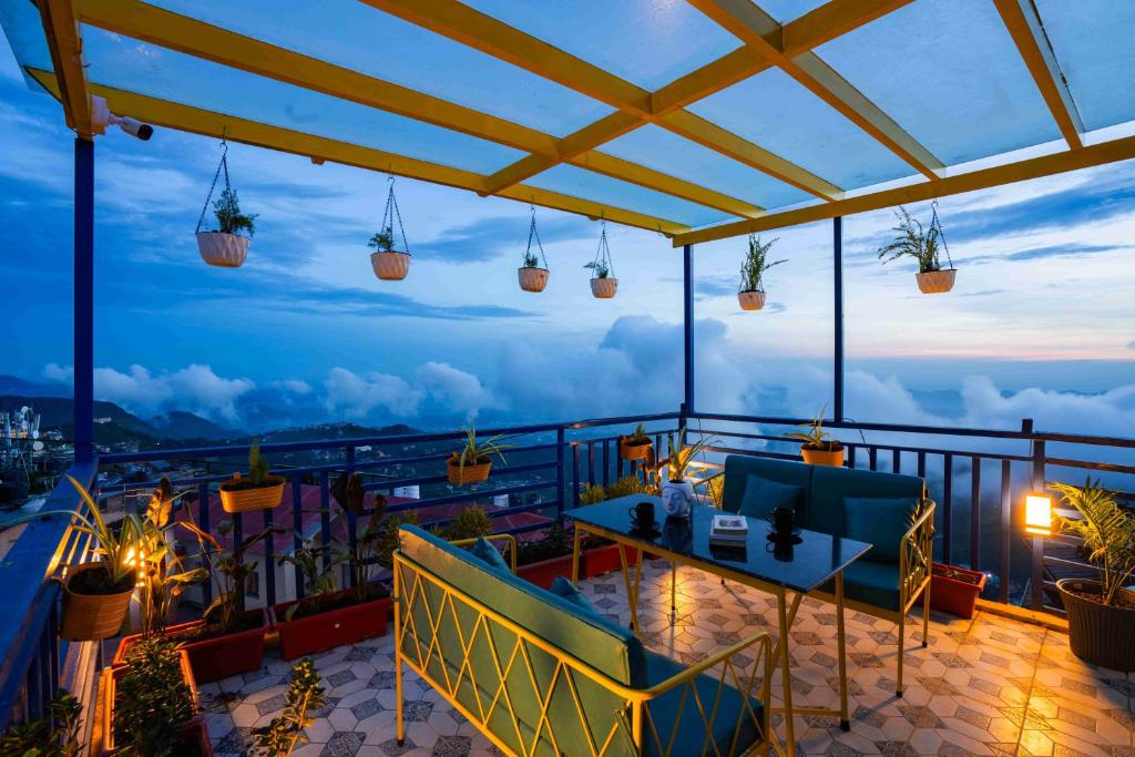 穆索里Shalom Backpackers Mussoorie的阳台享有风景,配有桌椅