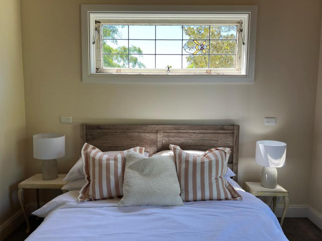 EwingsdaleSunset Cottage, Byron Bay的一间卧室配有一张床,楼上设有窗户