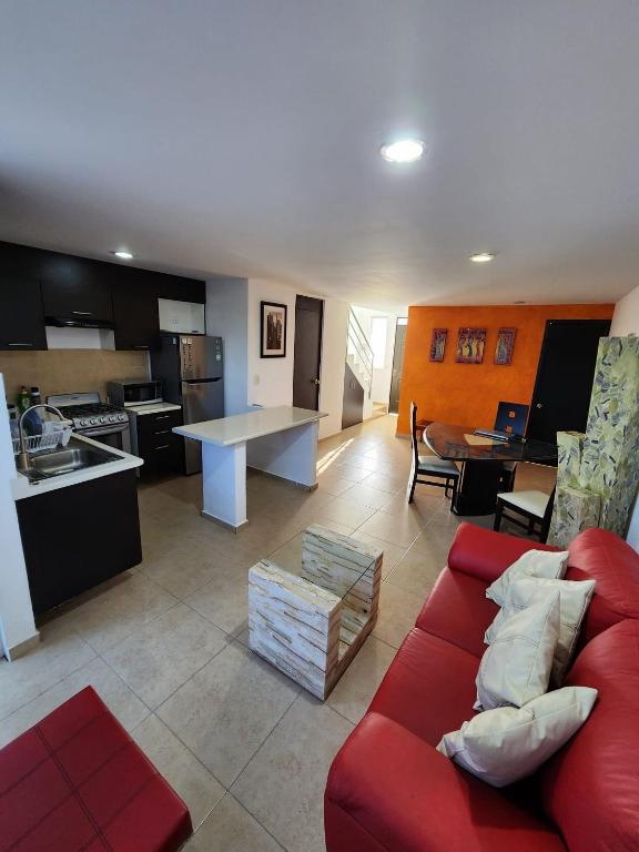 阿特利斯科Rinconada Cabrera的一间带红色沙发的客厅和一间厨房