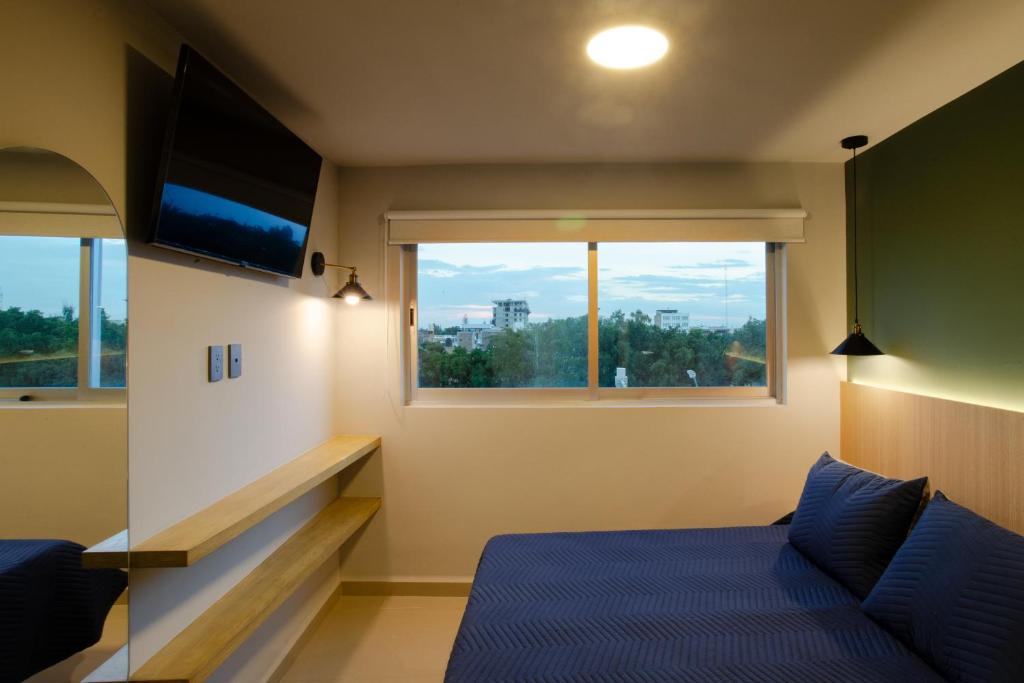 莱昂La Hospedería León的一间卧室设有一张床和一个大窗户
