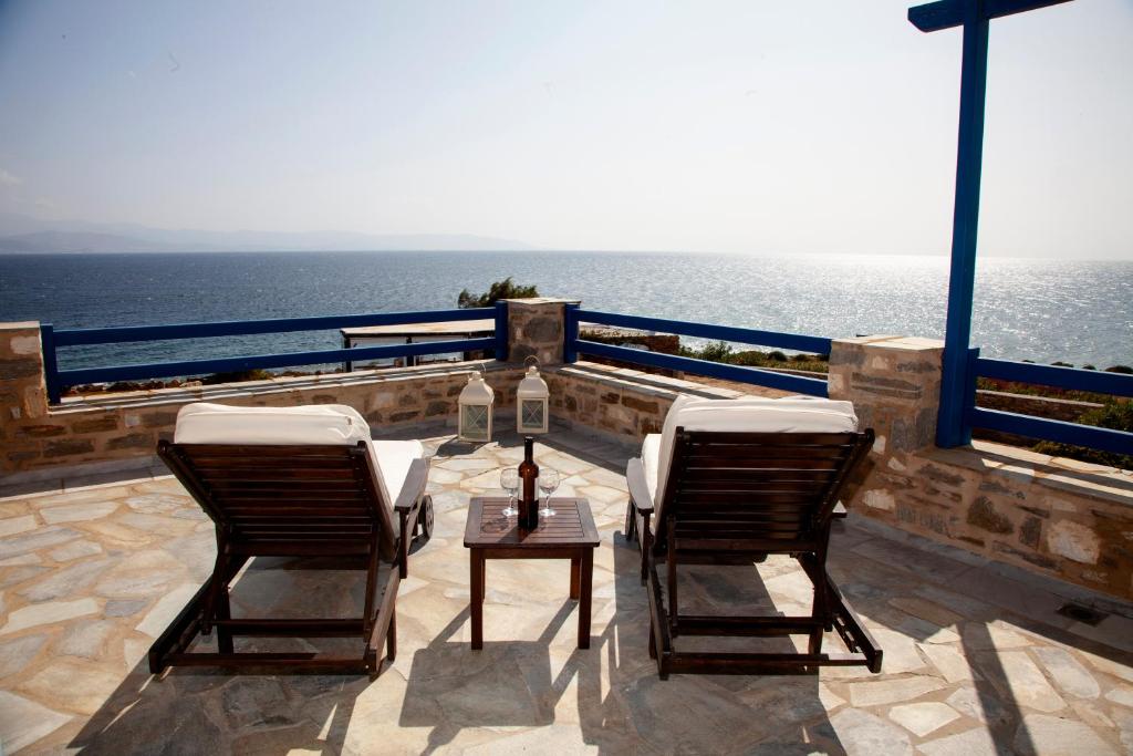 洛加拉斯Aura Paros的阳台上配有两把椅子和一张桌子,享有海景