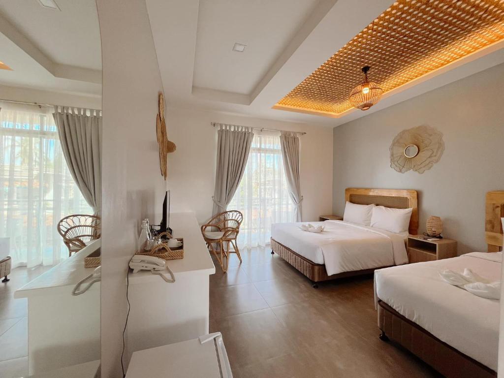 道伊斯Anlio Resort的酒店客房带两张床和一张桌子以及椅子。