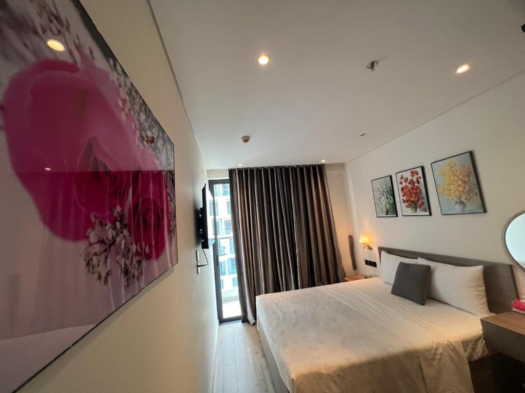 绥和市Apec Mandala Phú Yên的卧室配有一张床,墙上挂着一幅大画