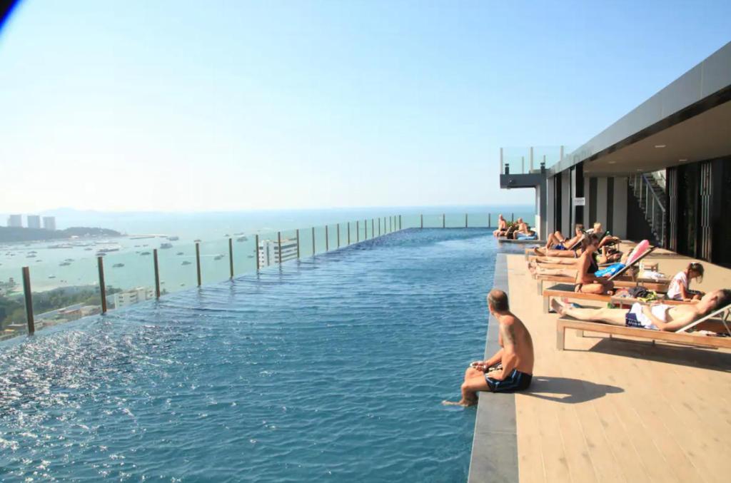 芭堤雅市中心Best Location In Pattaya, Sky Pool & Infinity Edge的一群人坐在游泳池边