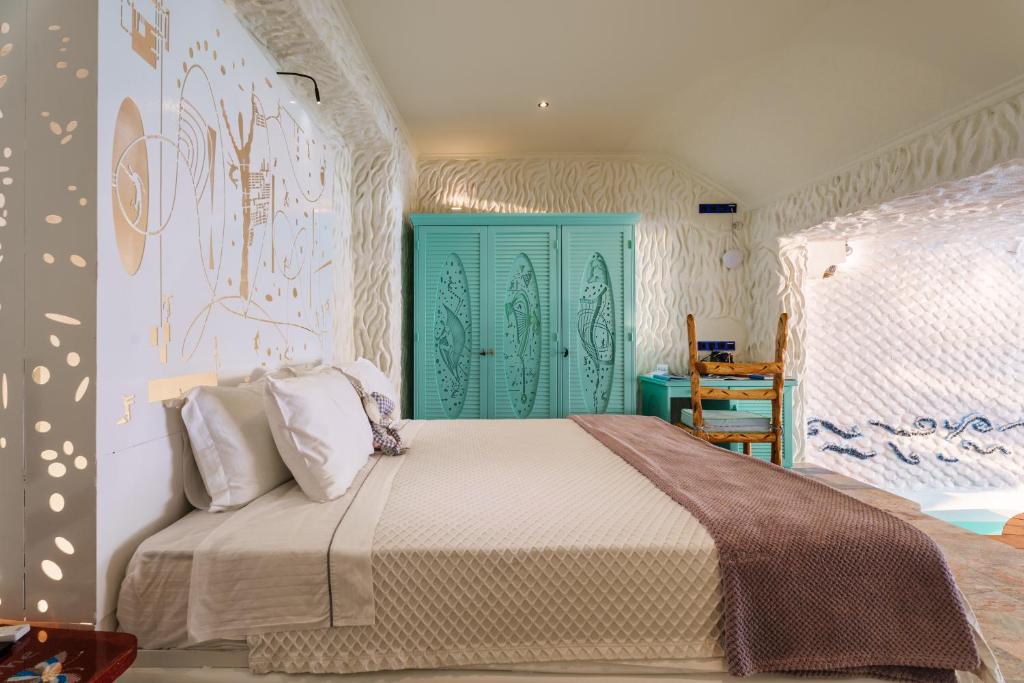 Tzamaria阿加利亚豪华套房别墅的一间卧室配有一张带绿门的床