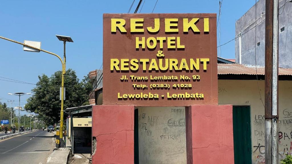 LewolebaHotel Rejeki的街上酒店和餐馆的标志