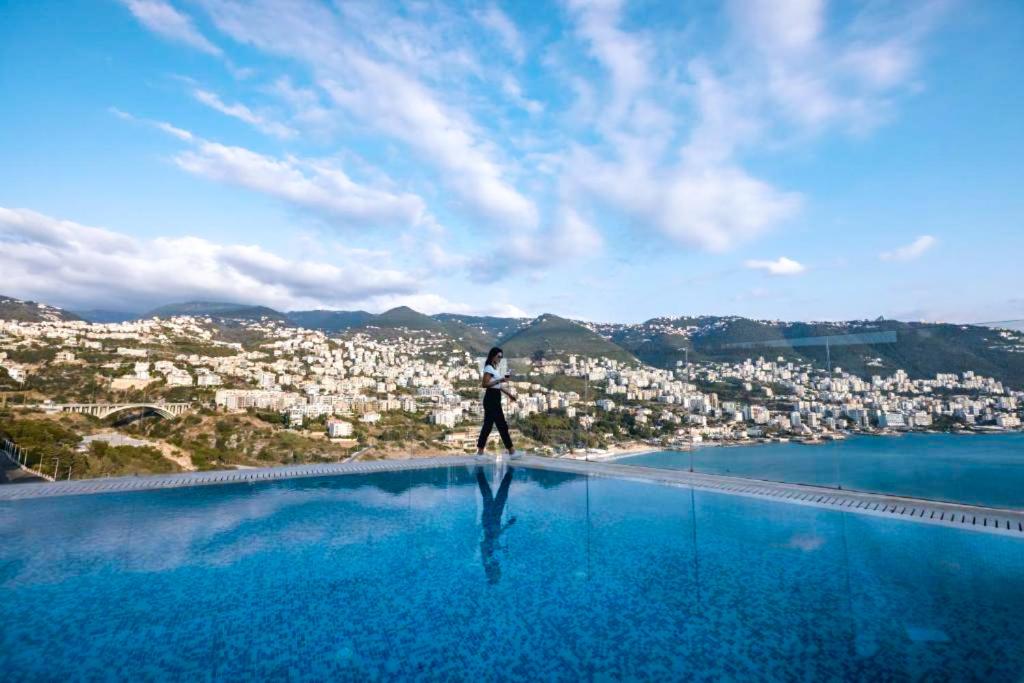 朱尼耶蒙塔卡西诺酒店的站在游泳池边俯瞰城市的人