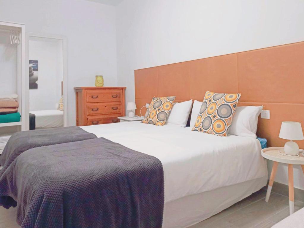 拉拉古纳Live La Laguna Gracia的卧室配有白色大床和木制床头板
