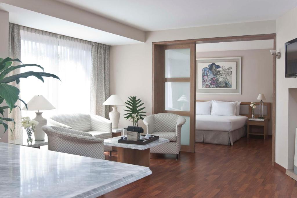 科尔多瓦科尔多瓦乌尔巴诺NH酒店的客厅配有床和桌椅