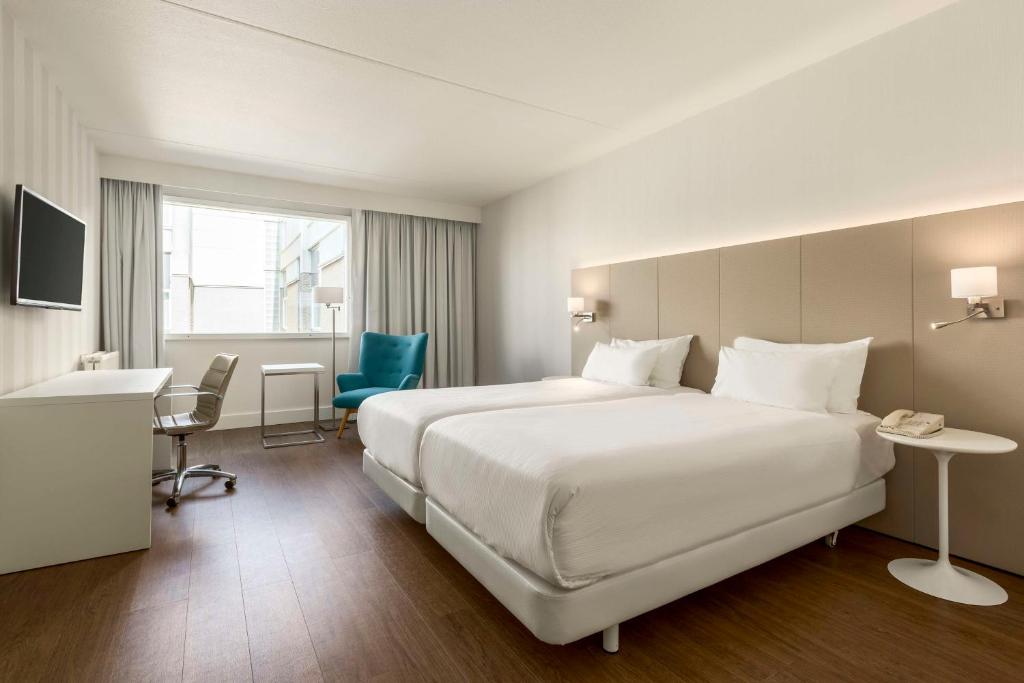霍夫多普阿姆斯特丹史基浦机场NH酒店的酒店客房设有一张白色大床和一张书桌