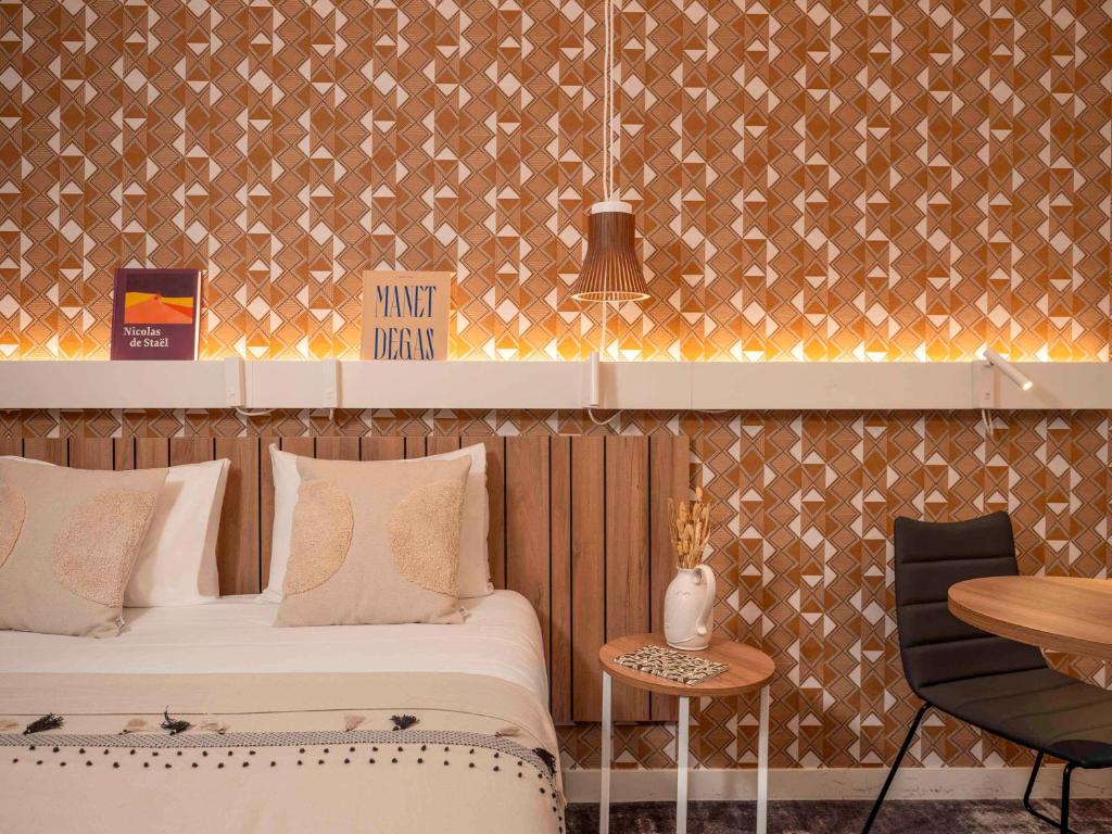巴黎Ibis Paris Gare Montparnasse Catalogne的酒店客房带两张床、一张桌子和一张桌子。