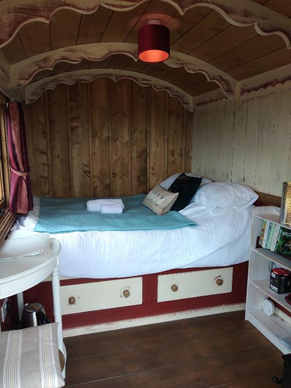 奇彭纳姆Shirehill Farm, Shires Barns的木制客房内的一间卧室,配有一张床