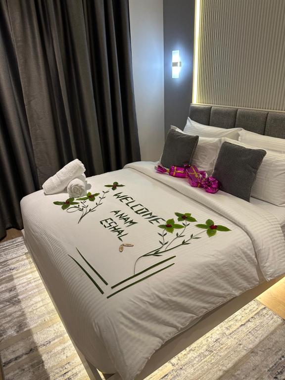 胡鲁马累Aira Residence - 2nd Floor 1007的一张床上的白色毯子,上面有鲜花
