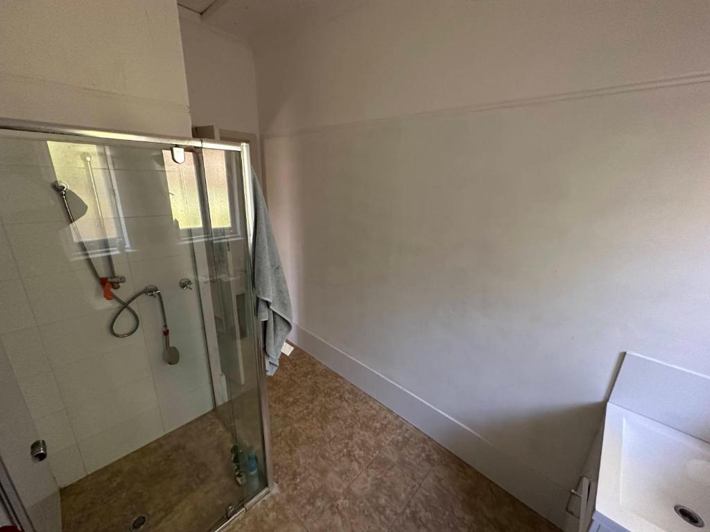 珀斯Chimu Home-Hostel的带淋浴和玻璃淋浴间的浴室