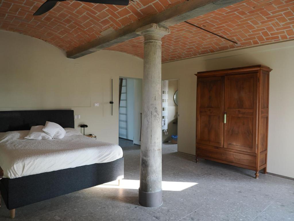 FabbricoA chalet in the Italian countryside的一间卧室配有一张床和一个木制橱柜