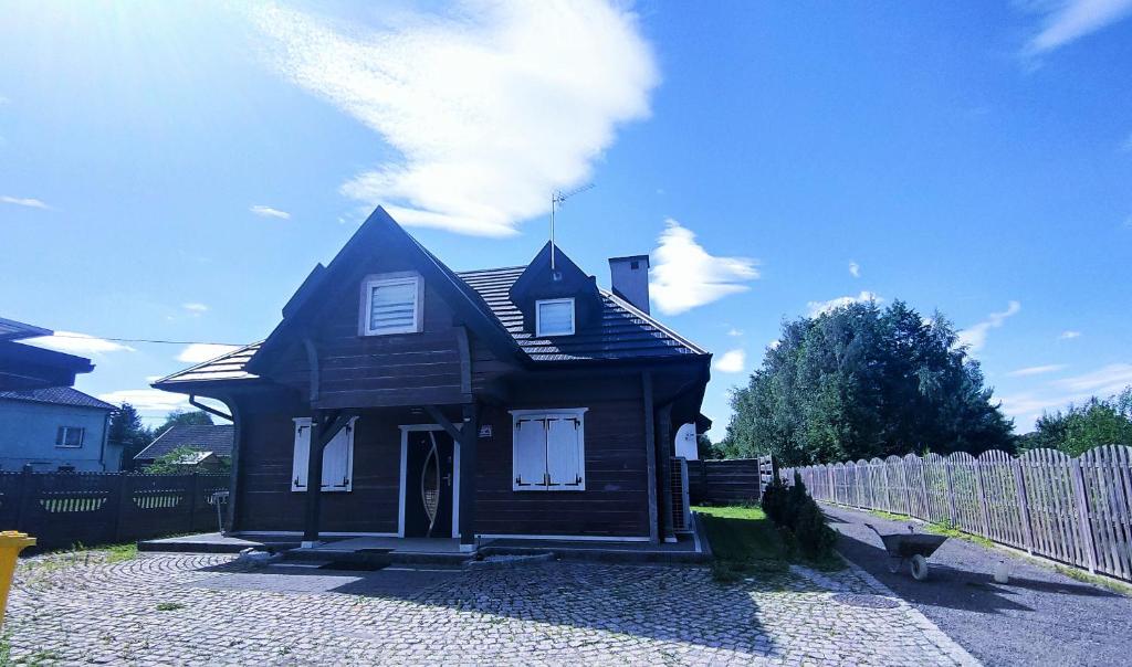 ChoczniaWille Myśliwska, Lux, Karo, Kier Chocznia的一间位于围栏旁的棕色小房子