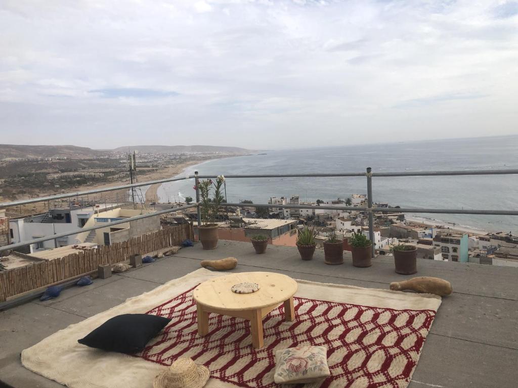 塔哈佐特Hostel blue house Taghazout的阳台配有桌子,享有海景。