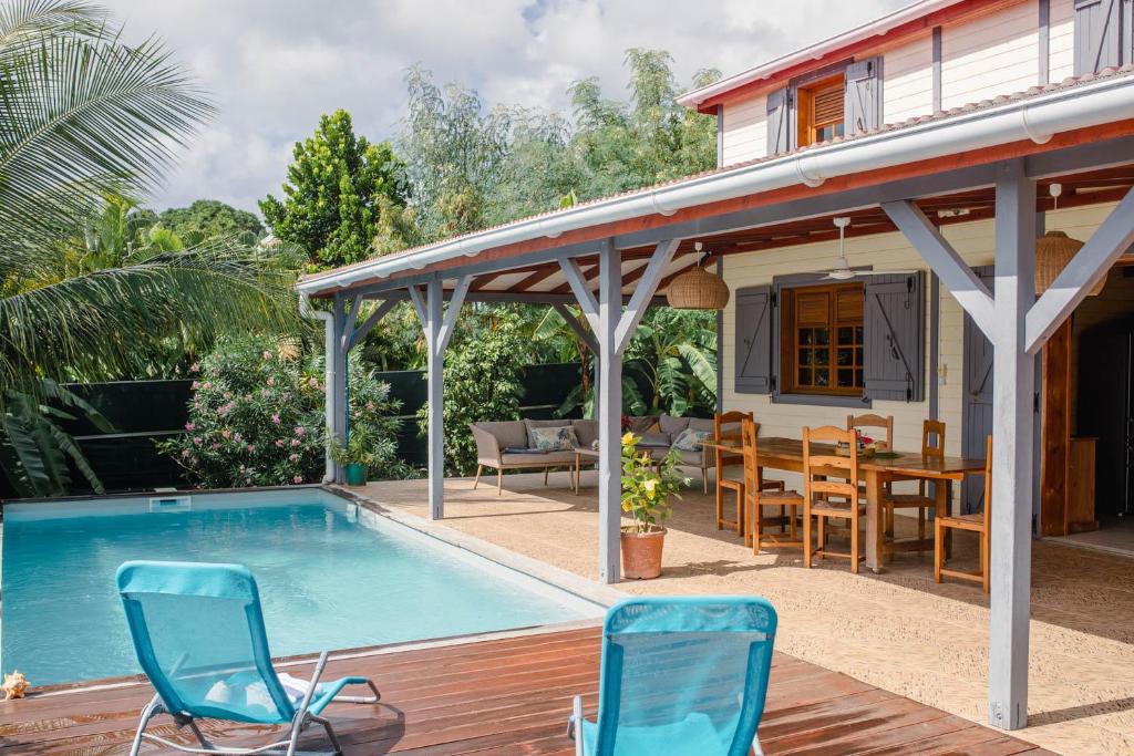 Saint-LouisDomaine Babwala, villa et bungalow avec piscine dans un superbe jardin tropical #cosy的一个带椅子的游泳池以及一座房子