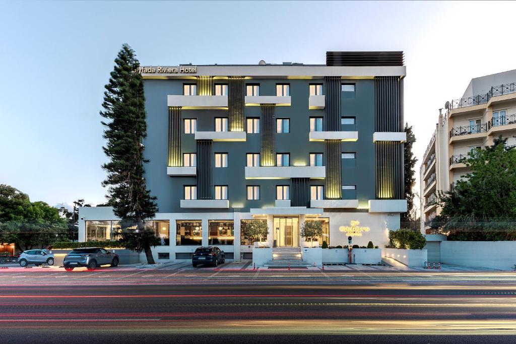 雅典Glyfada Riviera Hotel的前面有停车位的大楼