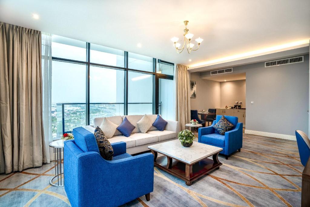 多哈فندق شراعوه الملكي - Luxury的客厅配有蓝色椅子和沙发