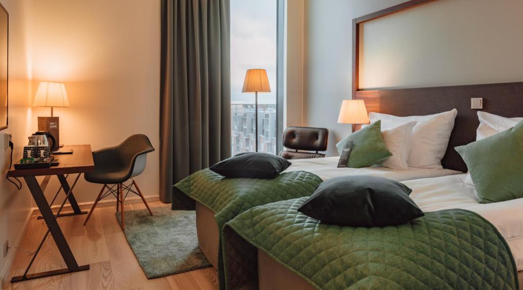 赫尔辛基赫尔辛基克拉丽奥酒店的酒店客房设有两张床、一张书桌和一个窗户。