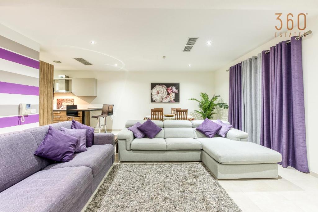 马尔萨斯卡拉A lovely 2BR home with a private balcony by 360 Estates的客厅配有两张沙发和紫色窗帘
