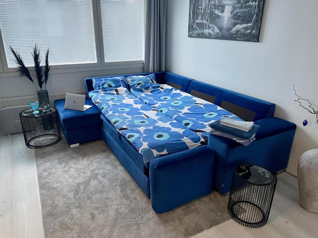 坦佩雷Modern room in the city centre的一张蓝色的沙发,位于带床的房间