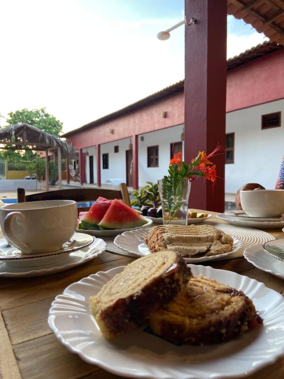 日若卡-迪热里科阿科阿拉Casa da Lagoa的一张木桌,上面放有面包、咖啡和水果盘
