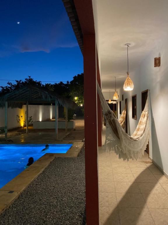 日若卡-迪热里科阿科阿拉Casa da Lagoa的游泳池畔的别墅,晚上配有吊床