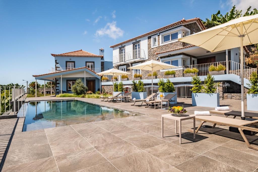 蓬他达维托亚Casas da Luz by Madeira Sun Travel的别墅设有游泳池和庭院家具。