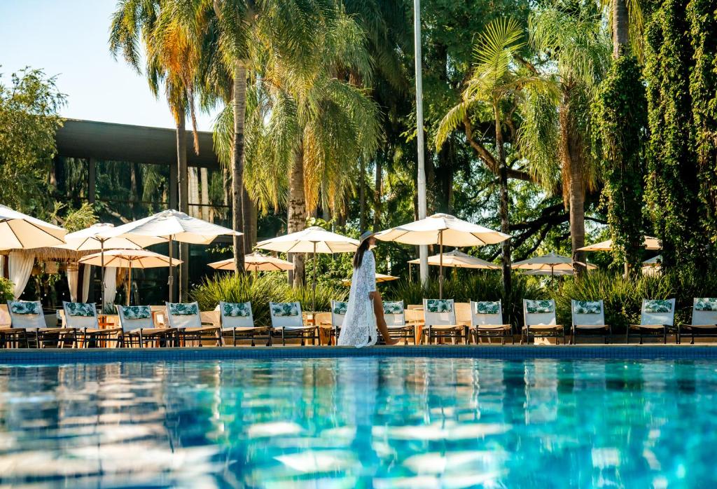 伊瓜苏维瓦卡塔瑞斯度假酒店的酒店游泳池设有椅子和遮阳伞