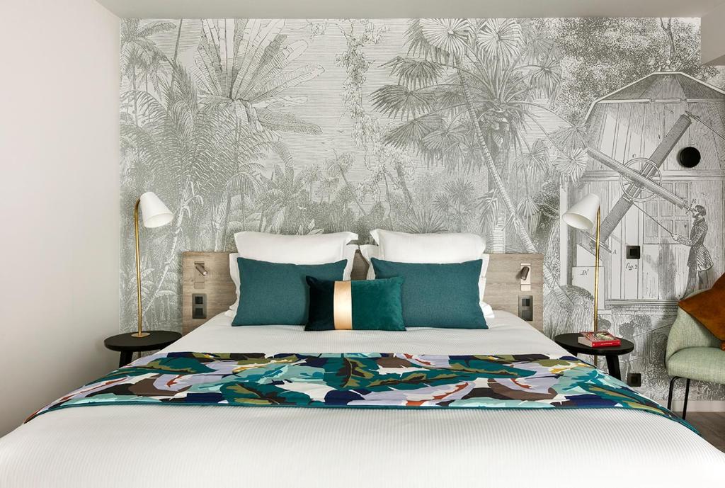 南特Citadines Confluent Nantes的一间卧室配有一张带热带壁纸的床