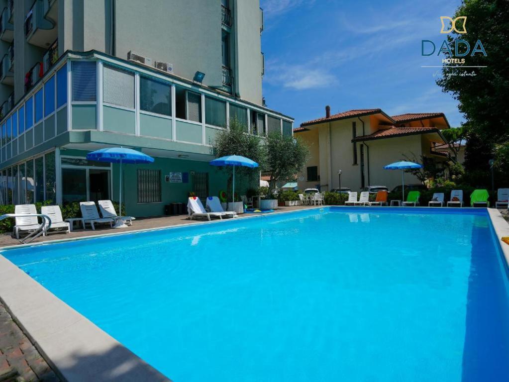 里米尼Dasamo Hotel - Dada Hotels的大楼前的大型蓝色游泳池
