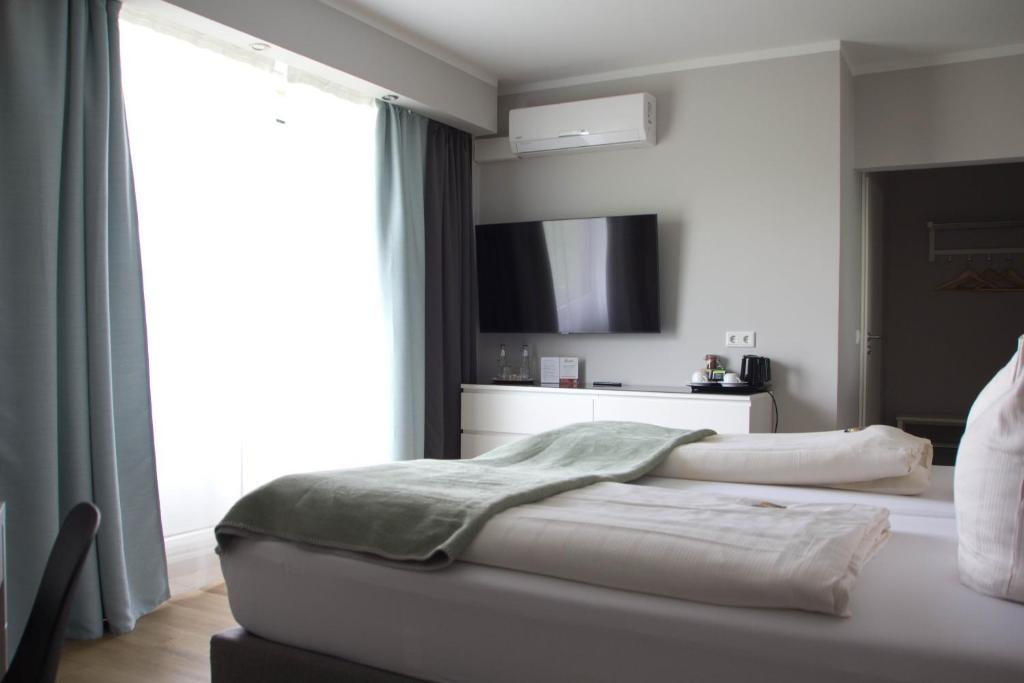 比勒费尔德塞纳图酒店的一间卧室设有一张床和一个大窗户