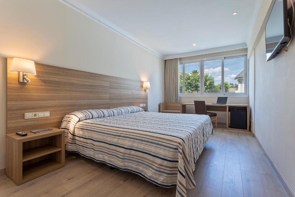 马德里Hotel Best Osuna的配有一张床和一张书桌的酒店客房