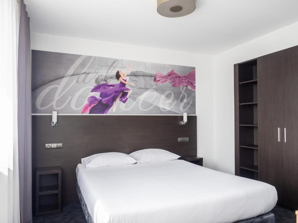 比托姆B&B HOTEL Bytom的卧室配有白色的床和墙上的绘画作品
