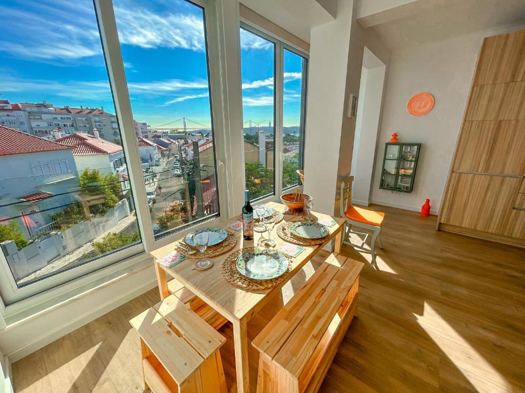里斯本Belém River Apartment View的配有大窗户的客房内的桌椅
