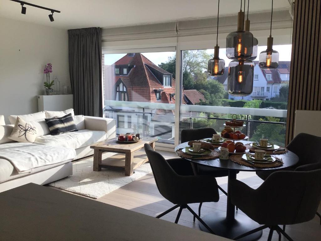 克诺克－海斯特Cosy Cottage Knokke的客厅配有白色的沙发和桌椅