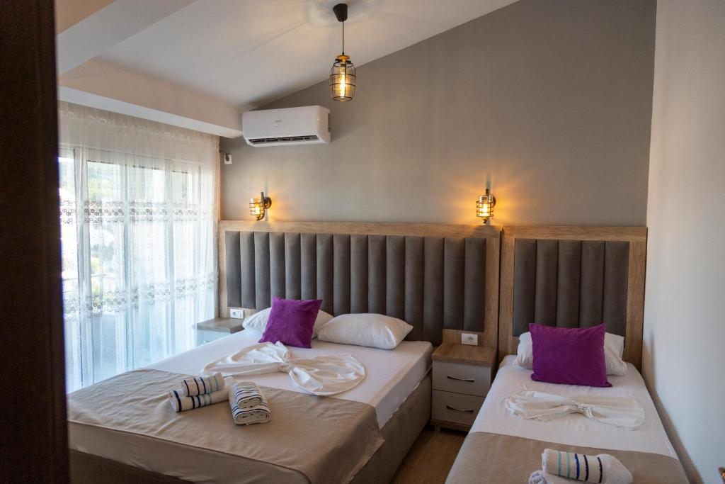 乌尔齐尼Kenzy Apartments的一间卧室配有两张带紫色枕头的床