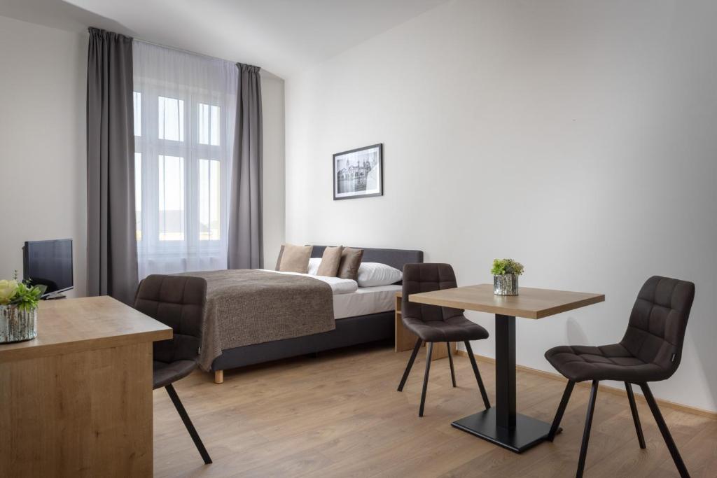 马达伯乐斯拉夫Residence Morris Mladá Boleslav的卧室配有一张床和一张桌子及椅子