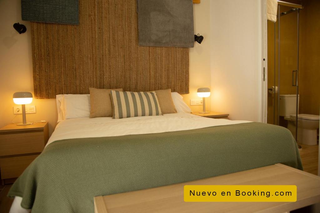 普拉森西亚HOTEL LOS ALAMOS BOUTIQUE的一间卧室配有一张带两盏灯的大型绿床。