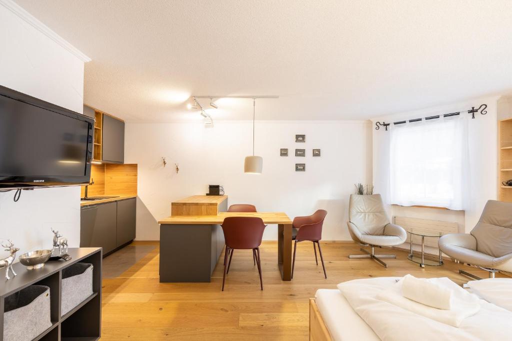 武尔佩拉7304 Pure Freude in dieser stilvoll renovierten Wohnung mit moderner Kueche的厨房以及带桌椅的起居室。